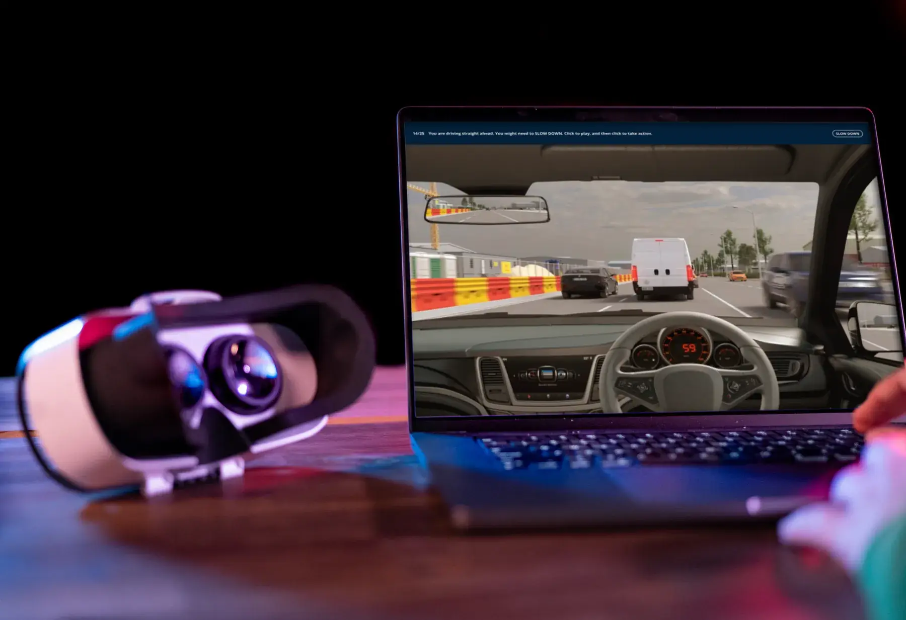 A VR headset beside a laptop showing a microVerse driving scene